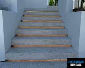 Concrete stairs with wooden steps leading up to a well-lit area.